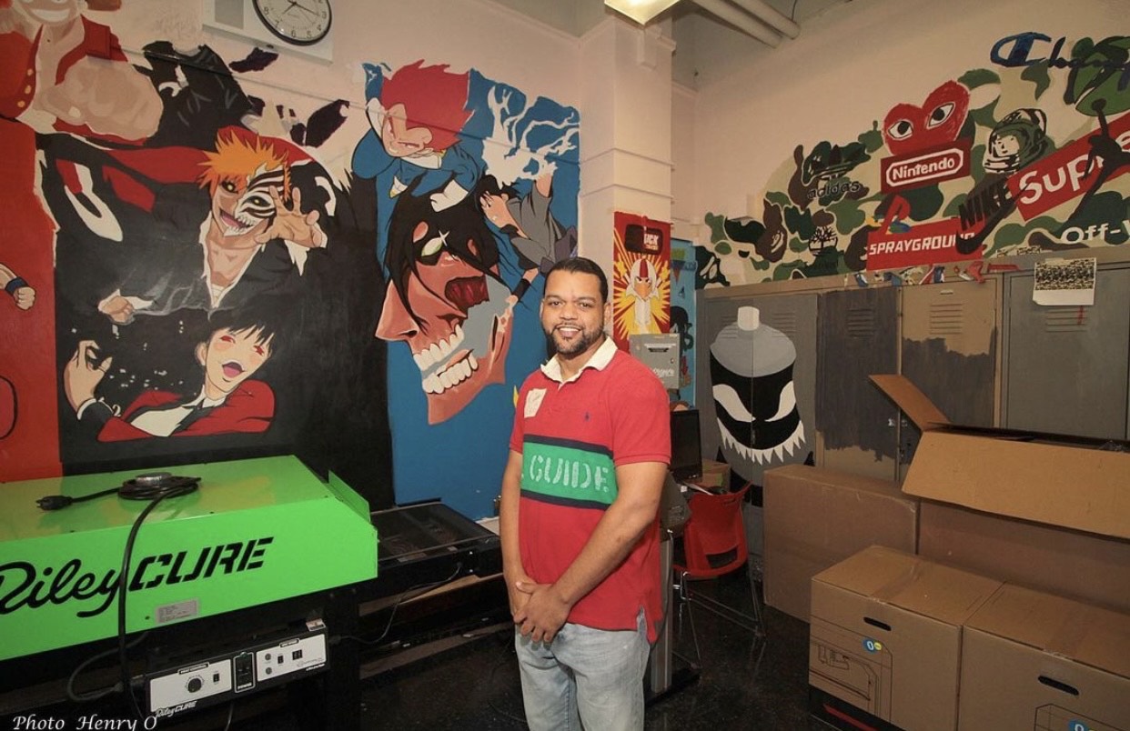 Clinton art teacher in the classroom in front of student mural work